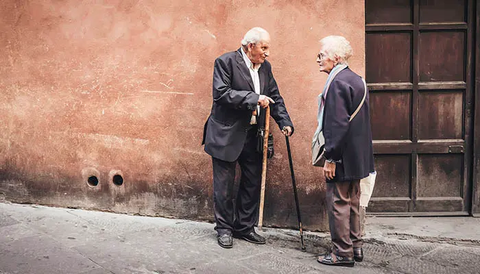 Un anciano y una anciana pasean por la calle